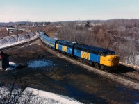 An MLW and GMD combine to lead VIA #72 eastward past the 'railfans lookout' at Hamilton West on Feb 24, 1987, one of nice chilly sunlit days, great for photography. Imaged are VIA 6779 and 6505. Time is roughly 1300. Photo taken with Speed Graphic 4x5 inch colour negative.