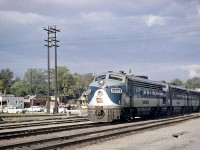 Wabash F7A 1161A leads two matching sisters on a freight through Chatham ON, on a sunny day back in October 1960. White flags waving in the wind (likely making this an extra), the train is heading westbound over Canadian National's Chatham Subdivision, crossing Queen Street by the CN station as cars line up waiting for the train to pass. <br><br> Part of an early 1951 order by Wabash to GMD London for 20 F7A's, 3 SW8's and a GP7 for their Canadian operations, interesting features on the 1161A include MARS lights in the top light assembly, silver outlined numberboard housings, the rounder passenger style pilots, and the square-topped winterization hatches found on some early GMD units. The Canadian Wabash F-unit fleet would later be renumbered into the 600-700 series, and when N&W absorbed the Wabash they became 3600-3700 series units. Leader 1161A would become WAB 670, and then N&W 3670. <br><br> For more Wabash F's: <a href="http://www.railpictures.ca/?attachment_id=15707"><b>F7A's 676 and 725 meet at Fort Erie ON in Summer 1964</b></a>.