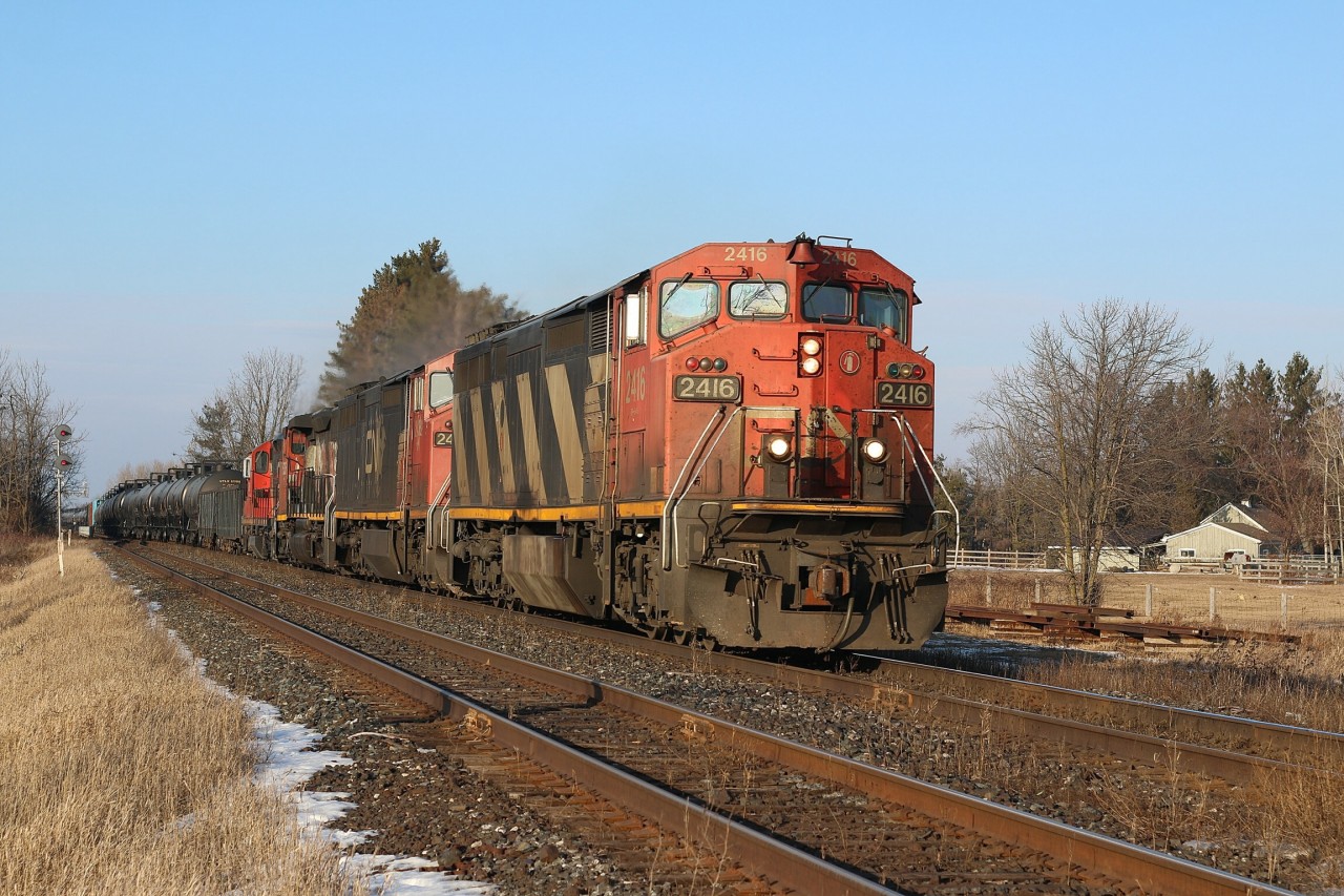 CN train 435 is back up to track speed after meeting train 148 in Georgetown. The train is re entering the double track after crossing the creek at Stewartown. Up front is a pair of cowl Dash 8s along with a SD40 and GP9rm.