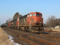 CN train 435 is back up to track speed after meeting train 148 in Georgetown. The train is re entering the double track after crossing the creek at Stewartown. Up front is a pair of cowl Dash 8s along with a SD40 and GP9rm.