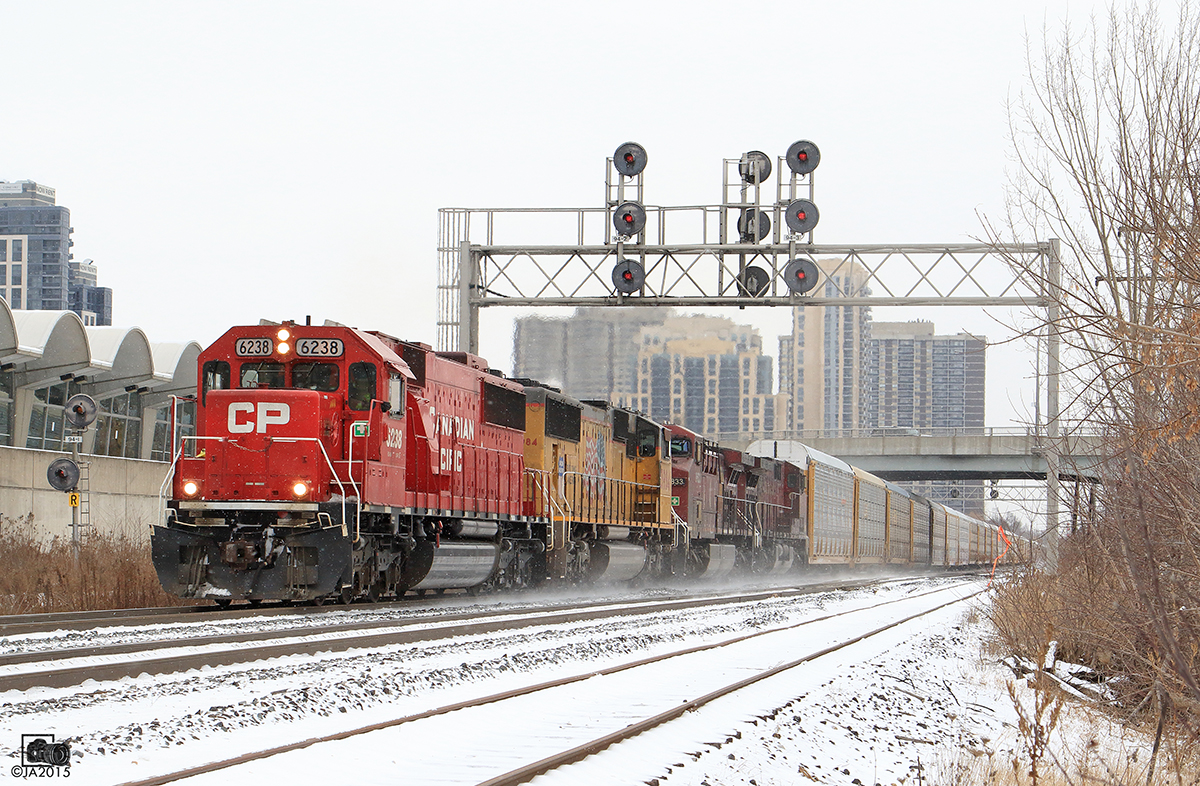 CP 6238, UP 3984, CP 9833 & CP 8533 , kicks up snow as it motors along pass Kipling.