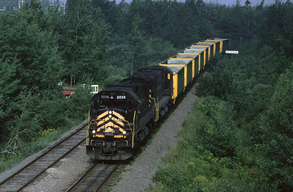 CBNS C630 2039 leads train #408 through Edwardsville, just east of the switch to the Point Edward spur. There is a cut of empty Devco hoppers on the head end, they carried coal loads west to the power plant at Point Tupper (or maybe Trenton) and will return to the wash plant at Victoria Jct. for loading.