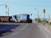 Some years ago, when Conrail (and before that, New York Central) has some presence in Niagara Falls, they ran transfers from Fort Erie/Welland over to the CN yard by way of the Niagara Industrial Lead, a line thru town that became history once the mainline thru the city's tourist area was removed. Here we see Conrail 7439 with a cut of hoppers crossing smack dab in the middle of the Bridge St/Victoria Av intersection in the Falls. Just in behind on the right one can see the elevated roadway over the CN Grimsby Sub. Such localized activity has all but vanished in the Falls, as it has in most railroad communities.