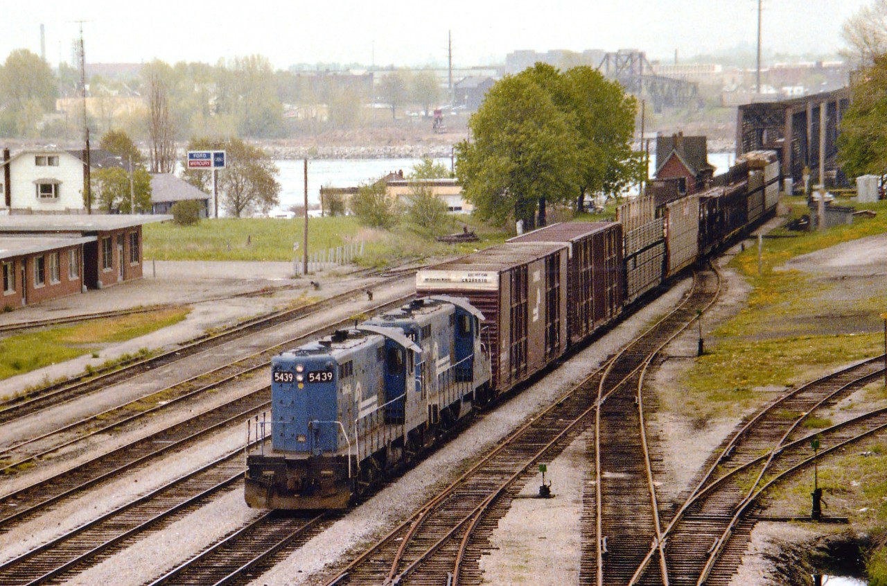 Unfortunately this old scene is a bit grainy, but one can see the daily Conrail transfer to Fort Erie from Buffalo stretches all the way back past the customs on the American side. This location has changed so much in the past 35 years since I wandered up on the Central Av overpass to bag this photograph. That modern CN/CP/MCR station on the left was boarded up in the 1980s (after the last CP passenger Budds) and demolished around 1999. The station right by the bridge, the old International Customs GTR brick structure, built in 1873, was moved to the RR museum on Central Av in May 1982, and on the right, where the stub tracks used by aeroplane part shipments by Fleet back in these days, there used to be a GTW station that was demolished some time in the early 1970s. And of course most of this trackage has been lifted. Second unit in this consist of what I believe were referred to as GP-10s is #5441. This caption is from memory so I am sure to hear from somebody. :o)