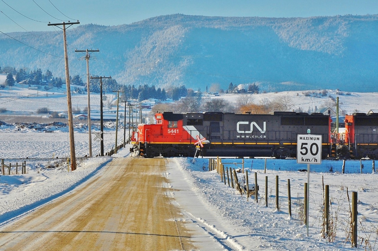 It's a cold afternoon in Spallumcheen as CN 5441 leads this southbound freight across L&A Cross Rd and on towards Vernon.