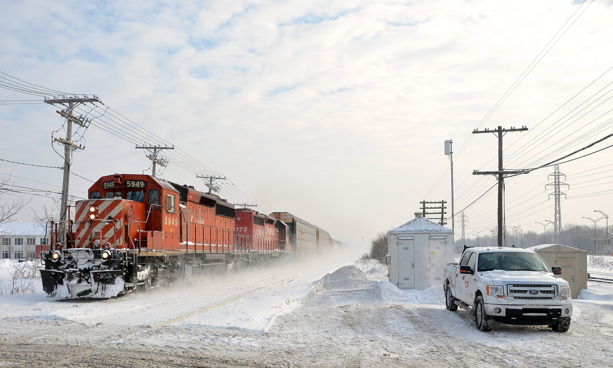 A pair of SD40-2's (CP 5949 & CP 5773) blast west through Beaconsfield with an unknown train which has 456 axles (possibly CP 241). At right is the truck of a CP foreman who had to manually key the Woodland avenue crossing. Further to the right is the CN Kingston sub.