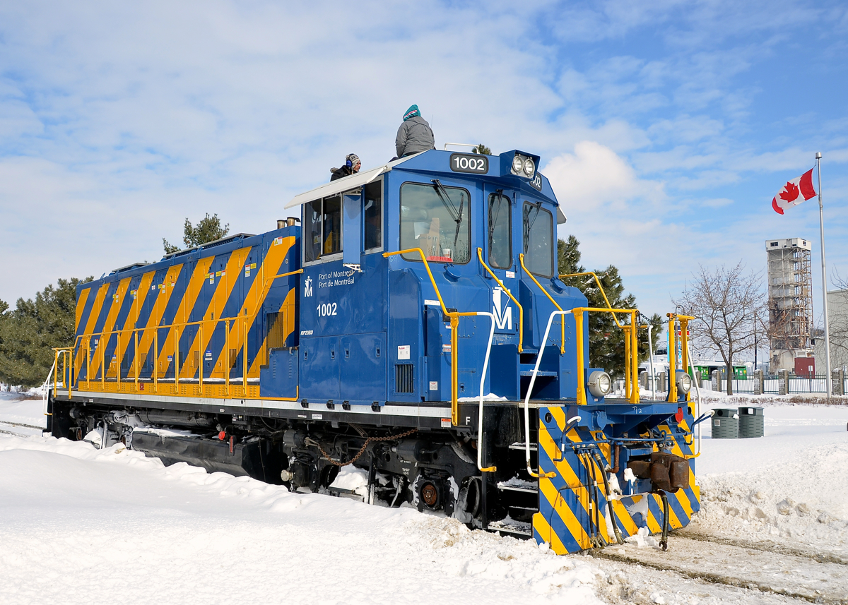 On top of a Port of Montreal switcher. POM 1002 is stopped to participate in the Old Port Symphony, an annual event which involves boats, trains and church bells making a lot of noise in the Port of Montreal. The people on top of the locomotive are involved in the event.