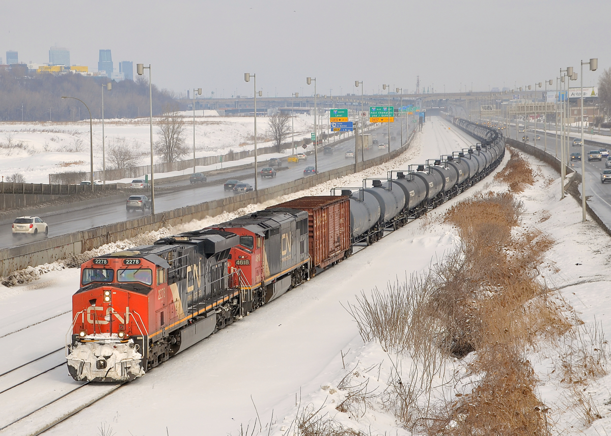 CN 2278 & repainted BCOL 4618 lead CN 305 towards Turcot West where it will get a new crew. In the background at left is downtown Montreal and at right is the Turcot highway interchange.