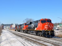 <b>A fresh leader.</b> A trio of GE's (CN 2911, CN 2689 & CN 2102) blast past the Saint-Basile-le-Grand AMT station with CN 120 for Halifax. Leading is a brand new GE ES44AC.