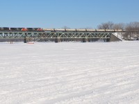 CN 705 (empty oil train for Alberta) is crossing the Richelieu River on a sunny but very cold morning. It has CN 8808, CN 2634 and an unidentified SD70M-2. At the head end are loaded TankTrain cars, with refined fuel for Maitland, Ontario.