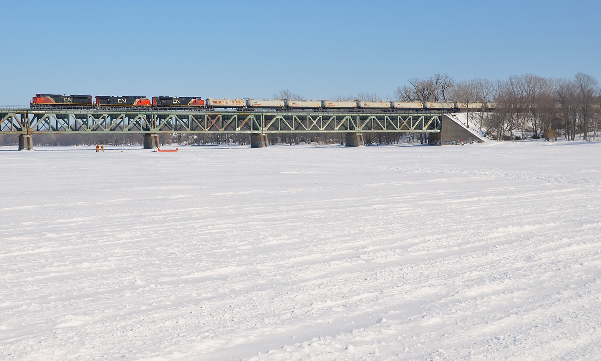 CN 705 (empty oil train for Alberta) is crossing the Richelieu River on a sunny but very cold morning. It has CN 8808, CN 2634 and an unidentified SD70M-2. At the head end are loaded TankTrain cars, with refined fuel for Maitland, Ontario.