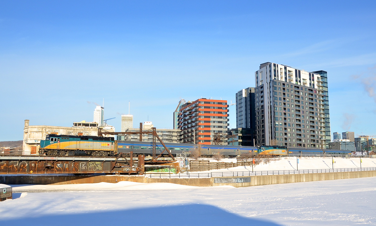 VIA 6431 is at the head end of the combined VIA 601/603 train as it passes the Peel Basin south of downtown Montreal. Until Hervey Junction in northern Quebec, VIA 601 to Jonquière and VIA 603 to Senneterre run as a combined train. Each train has an F40, a stainless steel coach and a stainless steel baggage car. The second engine is VIA 6438.