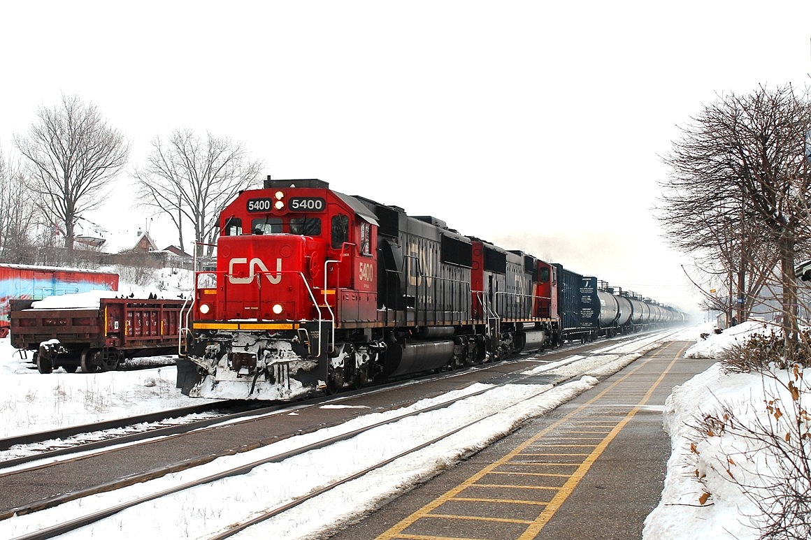 A very short 331 of only tank cars and a centrebeam as a barrier car speeds west through Woodstock on the north track. Locos in charge CN5400 and 5615.