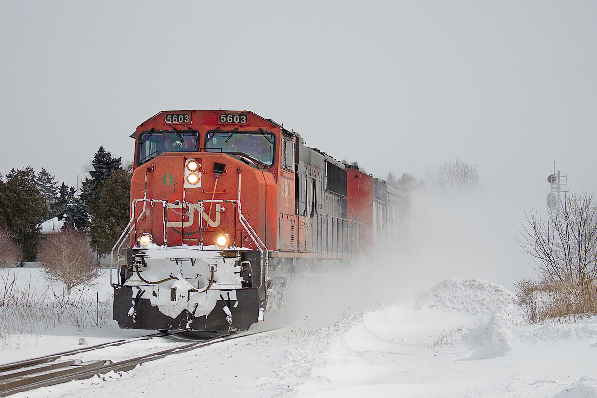 All trains were a later than usual this morning. Even Via 97, which managed to stay on time for a while, got nailed by the hotbox detector at mile 18.9 for carrying a good chunk of ice. Here, CN 422 passes Jordan after noon with three locomotives, CN 5603, CN 5553 and CN 5287. Don't believe me? It's okay, I didn't think you would. The nice layer of powder from a lake effect has not subsided since 331 passed earlier. Thankfully, it got a bit warmer. The feel temperature still hovered around -30 however. Thankfully, the actual temperature never got that cold, otherwise all trains would have to restrict to 30mph. The RTC neglected to put any trains on the south track all morning, however, I believe CN 330 used it later that night. 331 and 422 were both very short, and 422's length of 60 cars was especially surprising. Perhaps the long weekend had something to do with it.