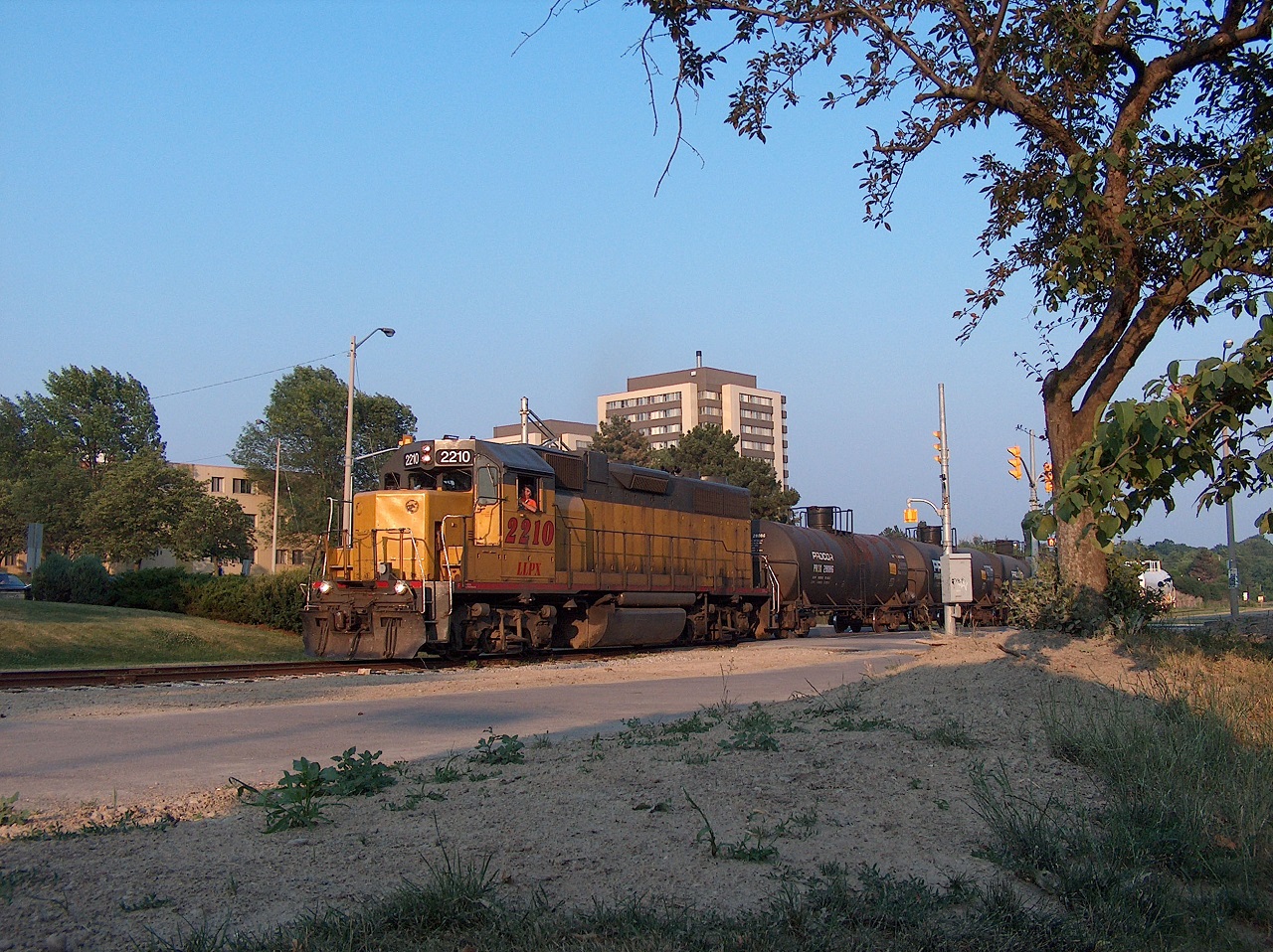 Ah, summer (well, technically very late spring)! The GEXR wayfreight to Elmira trundles northward on the Waterloo Spur just after 19:00 on a hot, sunny evening. They are crossing University Ave. at the University of Waterloo.