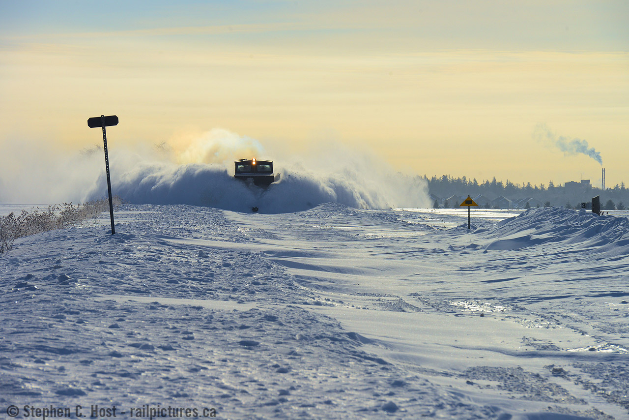 Battlefield: While suburban Stratford residents enjoy a morning Family Day coffee, the Goderich-Exeter Railway crew are busy battling mother nature. Accelerating out of town limits, a dark and ominous looking cloud of snow is cast aside into adjacent farmers fields. At centre: GEXR's black, hardened, 1938 built snow tank, 55413 - the war room for the winter battle. A few smooth drifts of snow have formed within the right of way, in contrast to the jagged chunks cast aside, clear evidence of prior battles with 55413. Sorry about your luck, mother nature, but you lost, and Spring is just around the corner.