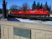 At Preston, T72 is southbound crossing the Speed River, gently rolling with 53 cars down the 2.5% grade (One of the steepest grades in the east on the CPR). Destination: Wolverton yard.<br><br>For a view from the other side of the bridge (viewed from a spot at far left, upper part of King st) from the 1950's see the link below:<br><a href=http://www.railpictures.ca/?attachment_id=10298>http://www.railpictures.ca/?attachment_id=10298</a><br><br>Another interesting fact is this curved bridge - was built by the Galt, Preston and Hespeler railway in 1896 is largely unchanged today, with exception to the fairly recent addition of a walkway and handrails. And where I'm standing? In 1896, imagine a switch where the first autorack is, and a second wooden rail bridge traversing straight towards me.  Freight trains took the bypass as you see here, and passenger trains ran right down King St, until 1937, when everything switched to the freight line - essentially the present day CPR Waterloo subdivision as it is known today. Source: Roth, George. Steel Wheels along the Grand, 2012.
