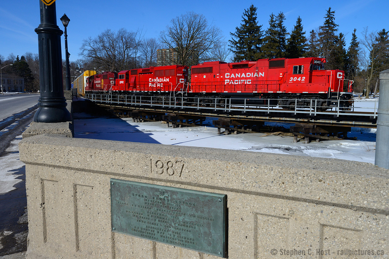 At Preston, T72 is southbound crossing the Grand River Bridge  after lifting 53 autoracks at Hagey. Destination: Wolverton yard.

For a view from the other side of the bridge (at far left) from the 1950's see the link below:

http://www.railpictures.ca/?attachment_id=10298