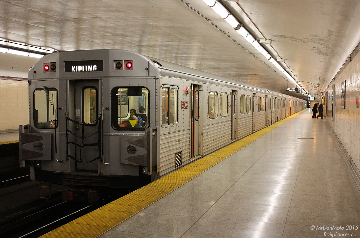 Late evening finds a set of Toronto Transit Commission H6 subway cars making a stop at Keele Subway Station to drop a few passengers off. Car 5903 trails, one of the group of 100+ H6 cars built in Thunder Bay by UTDC/Can Car Rail in the 80's (5810-5935). A bit more troublesome than the rest, an option for more new Toronto Rockets was exercised to replace the entire H6 fleet, and the last train retired in June 2014.

More H6's?
5911 at Woodbine Station: http://www.railpictures.ca/?attachment_id=13651
An H6 interior (pre-refurb): http://www.railpictures.ca/?attachment_id=15491
5886 departing Yonge in a flash: http://www.railpictures.ca/?attachment_id=15090
H6 train at Castle Frank: http://www.railpictures.ca/?attachment_id=4666
Zooming out of Sherbourne: http://www.railpictures.ca/?attachment_id=15492
Crossovers at Keele: http://www.railpictures.ca/?attachment_id=1807