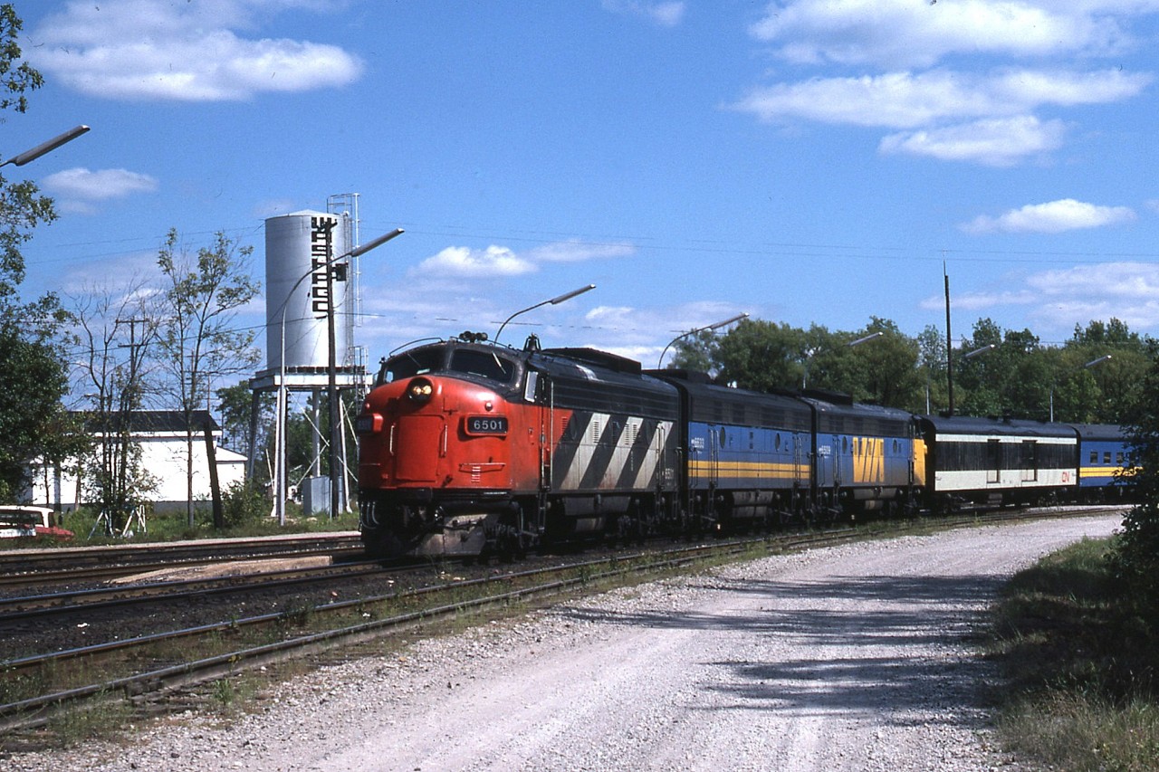 Northbound Toronto to Sudbury Jct connection of the Canadian at Washago. CN 6501, not yet painted to VIA, leads VIA 6633 and 6509. Units retired now save for 6509 which was rebuilt to 6304 then sold; it is currently stored in Wainwright, Alberta under private ownership. New watertower replaces old wooden leaker that existed until at least 1978.