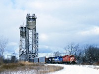 I have submitted a photo or two from this location before, but I feel this image best shows the scene from Hayes Rd (named for the Hayes-Dana plant that this road once led to)looking toward Bridge 10 over the Welland Canal and the City of Thorold. Due to work being done on CN's Bridge 6, CN Grimsby Sub, in the early winter of 1996/97 a handful of St. Thomas/Buffalo NS #328 trains were rerouted down from the CN connection at mile 9.49 (Merritton Sta) to Bridge 10 over the canal on the Thorold Sub and down to connect the CN Stamford sub at Port Robinson. The trains were rerouted only if they were later than approximately 10am. Once AMTK #97 cleared thru around 10 AM the work block went up. I know of only about 5 reroutes. So this was a rare catch; even more so because not long after this, Bridge 10 was deemed redundant and dismantled. The former CN line on the west side of the canal is now used by Trillium, and on the east side, the trackage from Port Robinson connects with Resolute, the big forestry plant in Thorold South. The track in this photo was pulled up a number of years ago as well. Power on this #328 is CP 5521, GATX 7371 and NS 6215. The view at this location today is just field and weeds. One would have to consider this an alternate route to alleviate the bitching and complaining by the mayor of Niagara Falls in regards to CN trains breaking down passing thru the city; that is, if the bridge and track had only been left in place. Much shorter route, too.