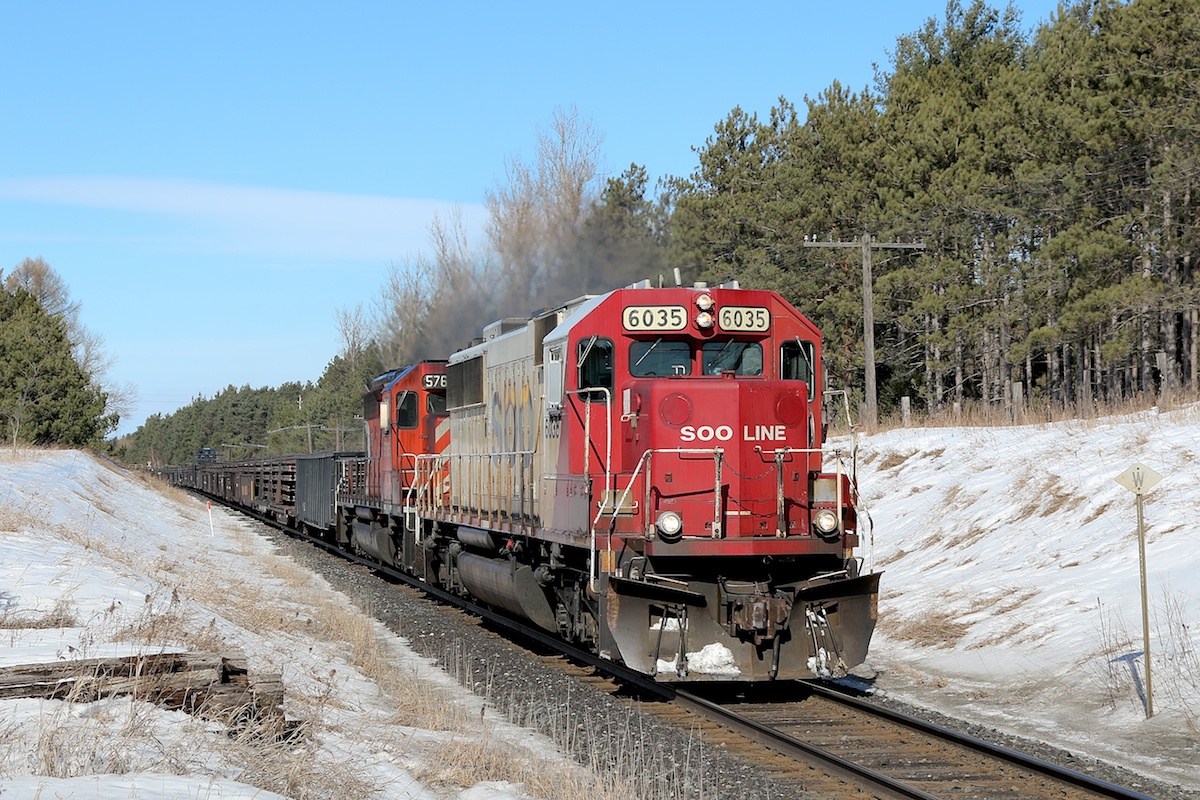 SOO 6035 slowly leads a rail train southbound out of Tottenham.
