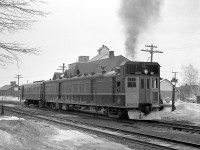 Canadian National "doodlebug" 15832 with a combine trailer in tow throttles up at the station in Stayner ON, enroute to Meaford. <br><br> Oil-Electric 15832 was built in 1930 by Canadian Car & Foundry, a self-propelled passenger car often known as a "doodlebug". Popular for use on branchlines or lines with low passenger ridership in the steam era, they were precursors to the widely successful Budd Rail Diesel Car (RDC) of the 50's. This car is painted in a variation of CN's typical yellow and green 1954 scheme, with a yellow front end and plow but with red front doors. <br><br> Stayner was Mile 22.8 on CN's Meaford Sub, which ran from the Bala Sub at Barrie 52.2 miles to Meaford. <br><br> <i><b>More on the Meaford Sub:</b></i><br> CNR 1322 at Meaford, 1958: <a href="http://www.railpictures.ca/?attachment_id=14023"><b>http://www.railpictures.ca/?attachment_id=14023</b></a><br> CNR 1527 leaving Meaford in March 1958: <a href="http://www.railpictures.ca/?attachment_id=15383"><b>http://www.railpictures.ca/?attachment_id=15383</b></a>