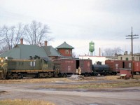 Canadian National RSC-13 1709 pauses at the Forest Station (Mile 47.5 CN Forest Sub), enroute from Stratford to Sarnia. A short train of box and tank cars from various railways is in tow, along with the standard orange wooden caboose on the tail end. The CN station is behind the lead unit, and the green water tower in the background bearing "Forest" in large letters places the photo well - the name of the town was actually given by the Grand Trunk Railway who built the line and station through the future town site, due to the dense forest in the area.<br><br>The unique A-1-A trucked MLW RSC-13 units were common on CN's light rail branch line operations out of the Stratford Division, but were eventually replaced or retired by more powerful units such as GP9's. A number were also later used as switcher and transfer units out of MacMillan Yard in Concord (Vaughan), with their trucks converted to B-B use with an extra long drop equalizer modification. The RSC-13 fleet was transferred from Stratford to Moncton in the mid-to-late 60's (with some to Montreal), and ran out their last days working CN's Maritime operations in New Brunswick and Prince Edward Island, retiring in the mid-70's. The units donating their A-1-A trucks to an RS18 upgrading program, making RSC-14's for branchline use, and were then sent out for scrapping. CN 1709 eventually ended its days at the London reclaimation yard in the early 80's, sent back west from NB on standard dummy B-B trucks to be cut up.<br><br>The CN Forest Sub ran from St. Mary's Junction (junction with the Thorndale Sub, 10 miles away from CN's nearby divisional operations base of Stratford) southwest 70.6 miles to Sarnia Junction, joining the Strathroy Sub at Mile 57.9. Most of the line was originally part of the GTR's mainline between Toronto and Sarnia. The portion west from Forest to Sarnia Jct was abandoned in 1982, and the rest of the line was gradually abandoned in portions throughout the mid-to-late 80's.<br><br>More CN RSC-13's in branchline service, at Harriston ON: <a href=http://www.railpictures.ca/?attachment_id=13990><b>http://www.railpictures.ca/?attachment_id=13990</b></a><br>For a photo of a CN local heading toward the Forest Sub in the steam era: <a href=http://www.railpictures.ca/?attachment_id=14281><b>http://www.railpictures.ca/?attachment_id=14281</b></a>