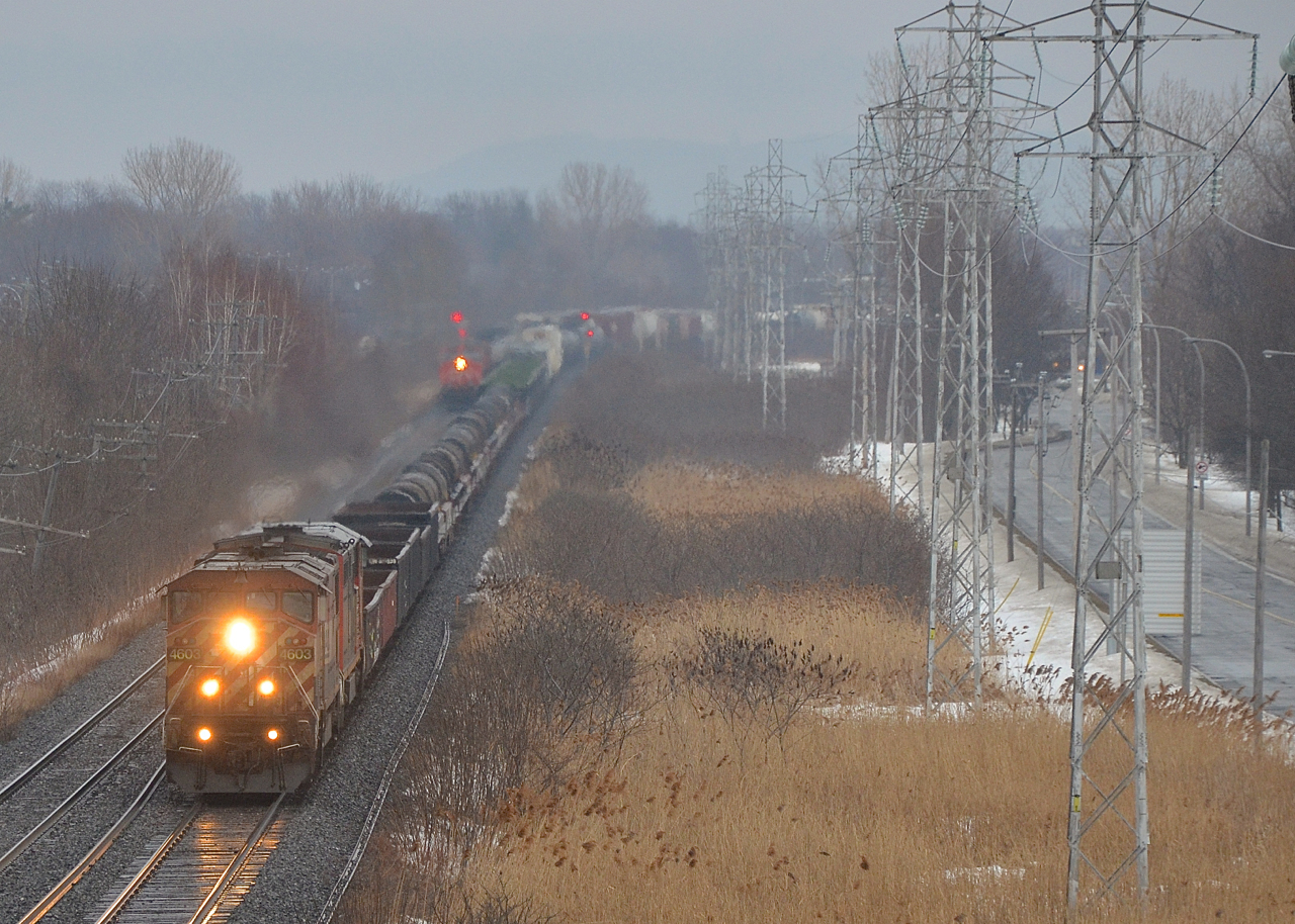 BCOL 4603 and CN 2435 head west on the south track of the Kingston sub on a rainy evening with CN X321. At left is the headlight of CN 373 (with CN 2229 and CN 2290), also heading west at the same time.