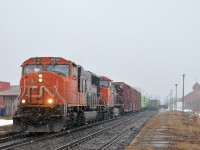 <b>You call this spring?</b> CN 327 has CN 5719 and CN 2606 as it heads west past the VIA Dorval Station at right and the AMT Dorval Station at left. At left is CP 112 heading towards the Lachine intermodal yard and stopped at right is a late VIA 62. Quite a bit of snow is falling on the first day of spring.