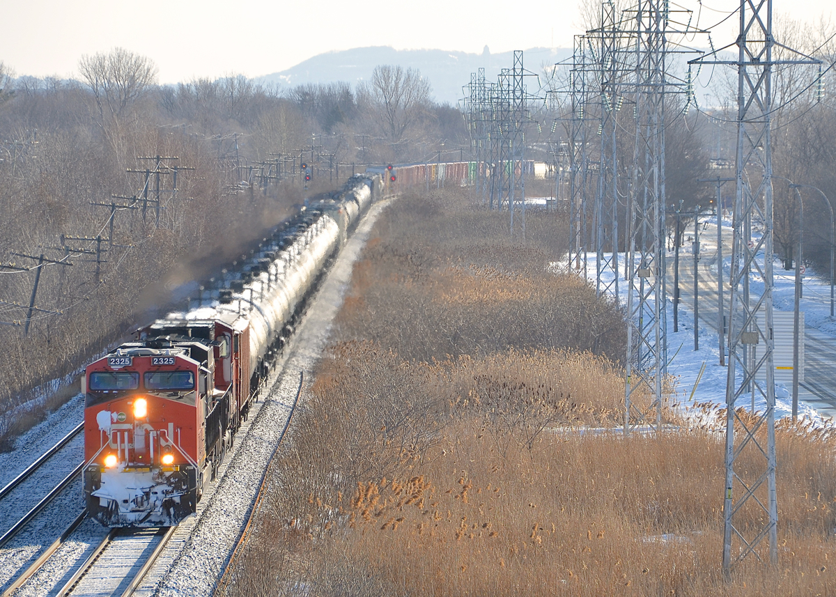 CN 305 heads west through Point-Claire, Qc on Montreal's West Island with a decent amount of snow on the train. It has CN 2325 & CN 2565 and CN 8915 mid-train.