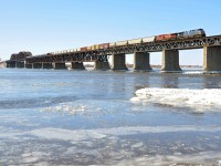 <b>Crossing the frigid St. Lawrence.</b> A fairly long CP 253 has CEFX 1006 & CP 8503 as power as it crosses the frigid St. Lawrence river on its way to the island of Montreal on a very cold morning.
