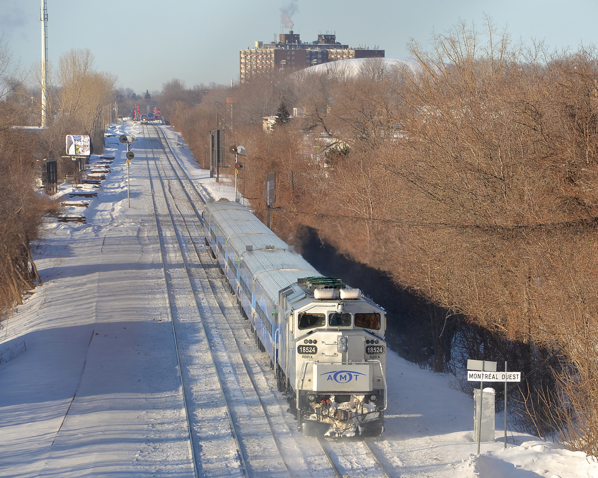 Ex-GO Transit RBRX 18524 pushes an AMT deadhead movement towards Montreal West station during the morning rush hour. The station is in the far distance, and two more AMT trains are visible there. Of note is that the rooftop radiators on the F59PH are still green.