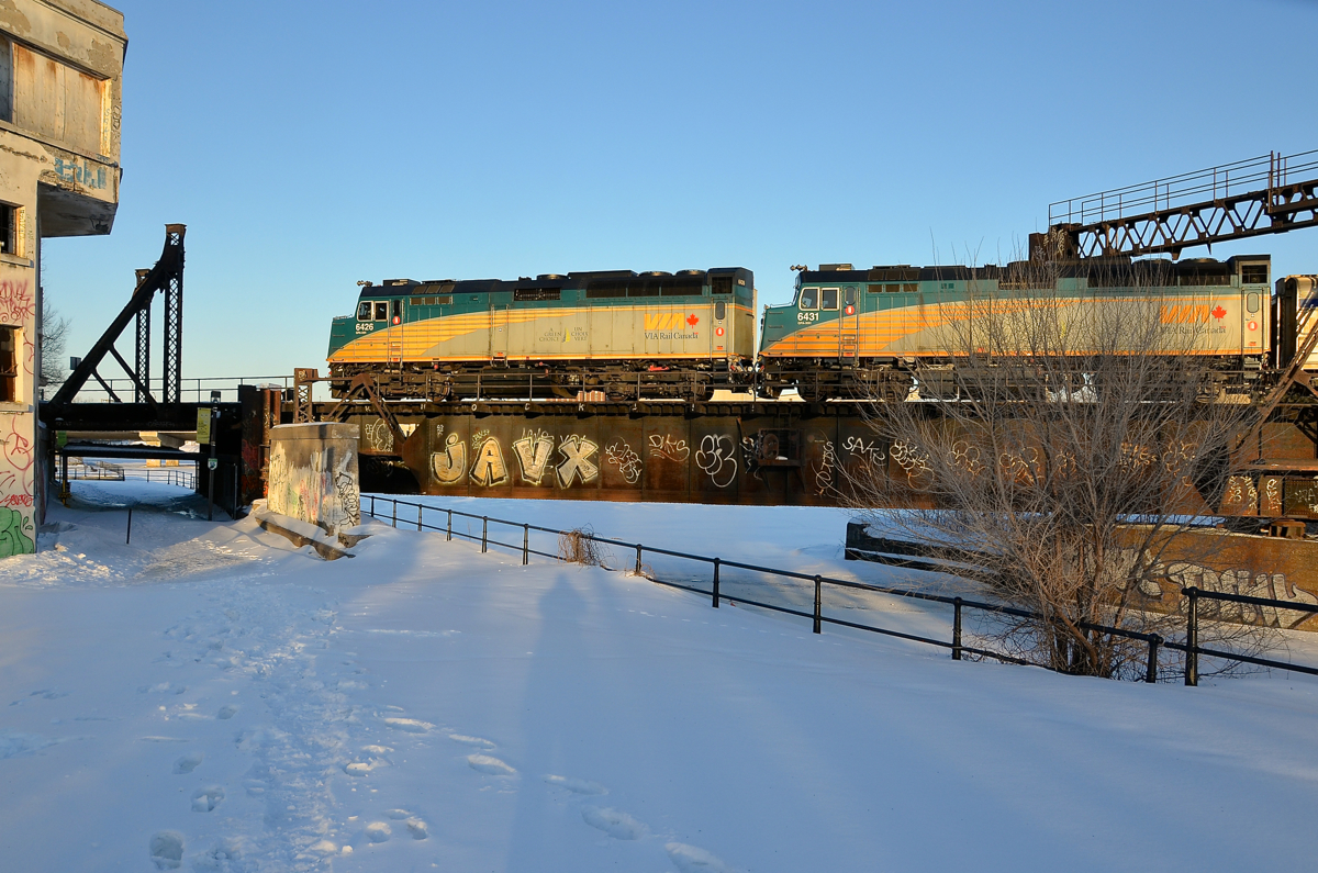 A pair of F40's (VIA 6426 & VIA 6431) lead a slightly late VIA 64 from Toronto over the Lachine Canal, with the CN Wellington tower at left.