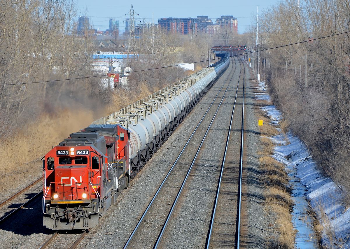 CN 705 has two of CN's secondhand units (CN 5433 & CN 2192) as well as some loaded TankTrain cars (destined for Maitland, ON) ahead of the oil empties. Here it heads west through Lachine.