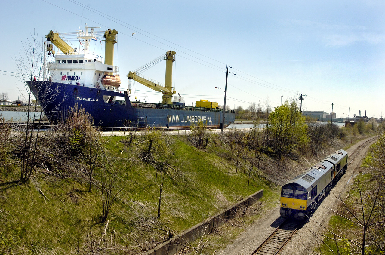 The last pair of a Nedrail (Netherlands) order for ten JT42CWR (EMD Class 66) locomotives are test run on the Trillium Railway in May 2006. ITS Rail assembled the locomotives under subcontract to EMD, at the ITS Rail plant in St. Catharines, ON.  As the locomotives are run south up the escarpment the Jumboship Daniella approaches lock 7 on the Welland Canal on its way to Toronto Harbour where the locomotives will be loaded for their trip to Europe.