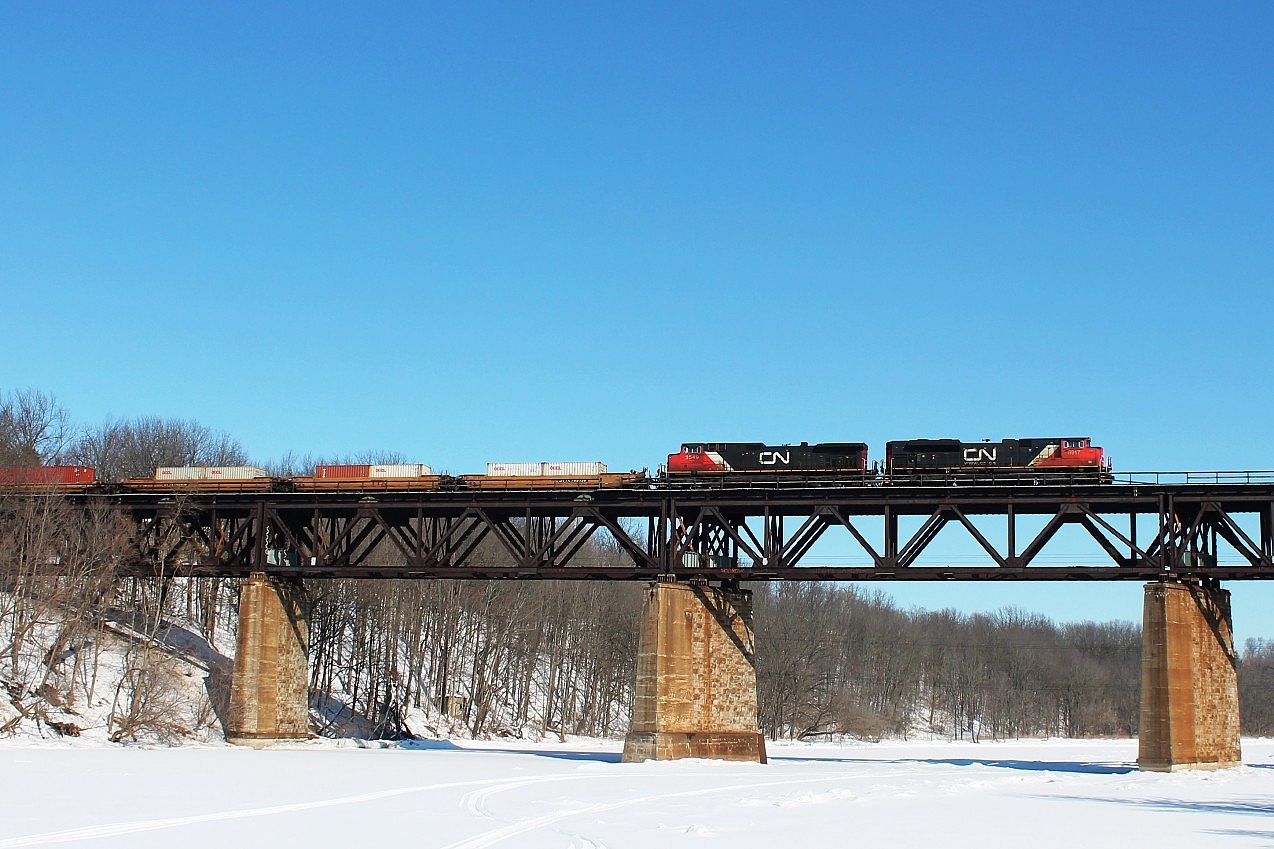 148 crosses a frozen Grand River hauled by CN 8917 and 2549. There were a lot of empty flats on this train.