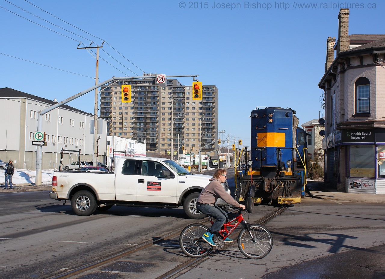 After completing their work at Ingenia, SOR 496 is seen shoving back up the Burford Spur with RLK 4003 and 4 hoppers.  They have just cleared Colborne Street and traffic is able to resume as they head back towards the Dundas Subdivision.
