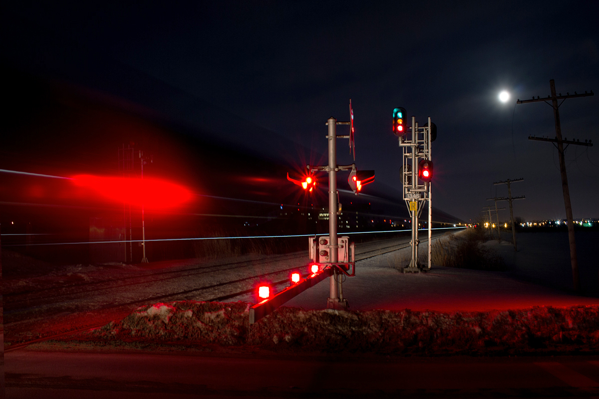CN 330 knocks out the south track signal at Third Street Louth in St. Catharines. About 400000 kilometers away, a full moon watches over Earth.