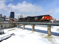 <b>CN 527 takes a detour.</b> CN 527 with CN 2332 and IC 1025 is taking a detour from its usual Southwark Yard-Taschereau Yard run to bring back a long string of empty grain cars out of the Port of Montreal. Here it is crossing the Lachine Canal.