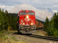 The sun pops out in the late afternoon, highlighting the head end of westbound CP 199, which is just west of the Continental Divide with Mount Richardson as a dramatic backdrop. 