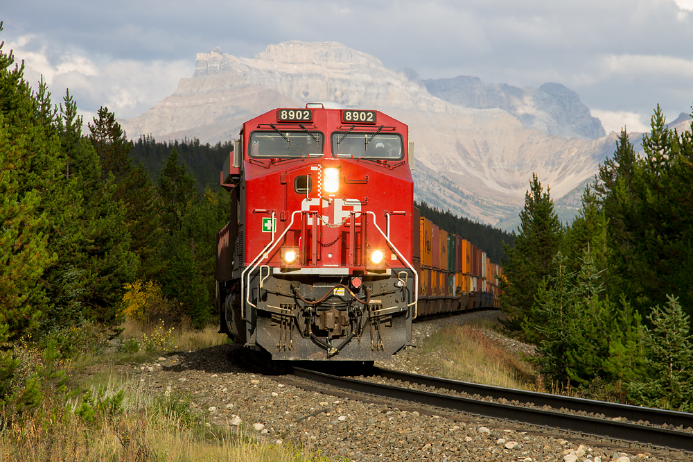 The sun pops out in the late afternoon, highlighting the head end of westbound CP 199, which is just west of the Continental Divide with Mount Richardson as a dramatic backdrop.