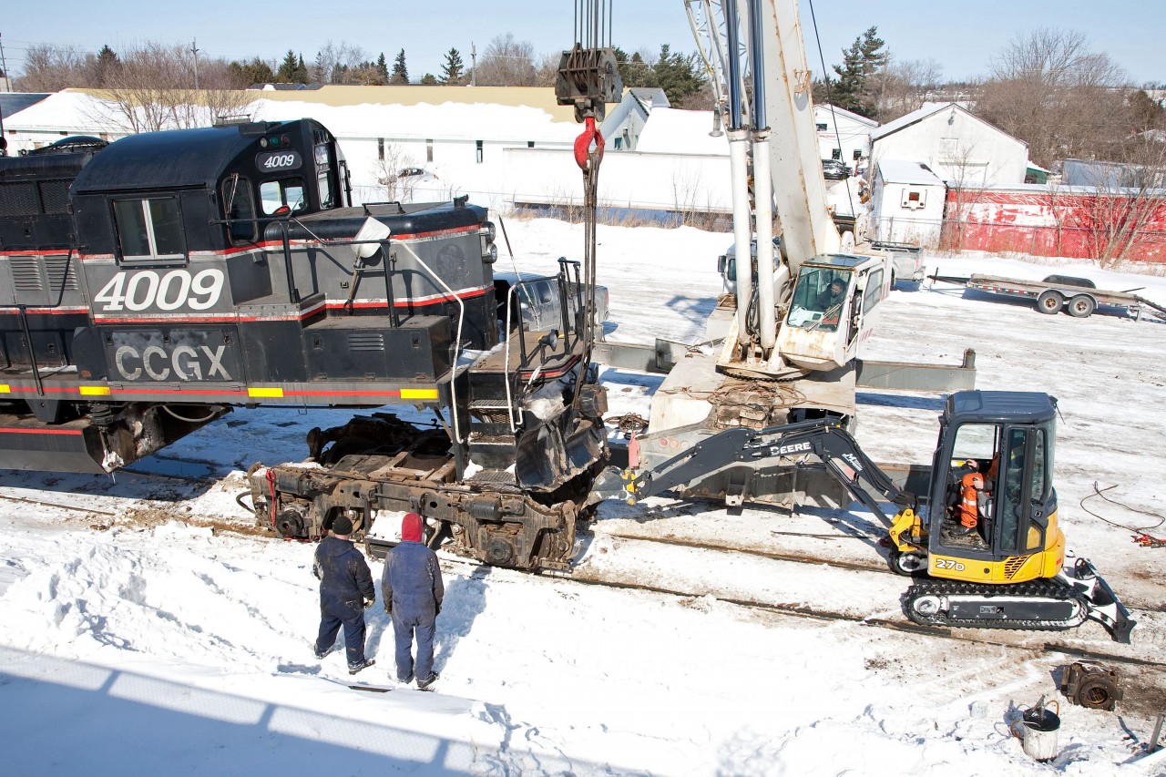 Unlike the Class 1's and a few larger shortlines, the OBRY does not have the luxury or convenience of a shop.
Everything, from changing brakeshoes to main generator change-outs are done outside, regardless of the weather.
A bitterly cold March 5, found the maintenance crew from Lambton Diesel Services changing the number 2 traction motor on 4009.  The new axle has been installed on the truck and is now being pushed into position so 4009 can be lowered.
Luckily there is a Tim's only blocks away !