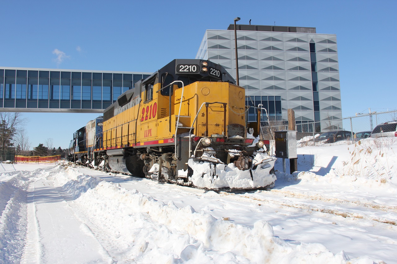 After I got word of GEXR 584 doing a daylight run to Elmira and back (thanks to Steve and Jon), I figured I should seize this opportunity and get some shots as the sun was shining nicely and runs like these are numbered. Here we see GEXR 584 creeping slowly south to the GEXR mainline with LLPX 2210 and RLK 4001 and five tank cars. They are going past the fairly new University of Waterloo Engineering building with overhead passageway to another building on the UW campus. Time, 14:29.