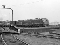 <b><i>Different power and different paint schemes:</i></b> resting near the roundhouse turntable at the Canadian National shop facilities in Windsor ON is a set of Norfolk and Western F-units, built for the Wabash Railroads' Canadian operations. By this time the Wabash Railroad was leased to the Norfolk and Western (before they took control in 1970 from majority owner PRR) and some power was already repainted. Witness F7A 3657 (ex-Wabash 657, originally 1155 and the first GMD-built Wabash F-unit) sporting the N&W livery, while the sister unit behind sports the later simplified Wabash livery, and the 3rd F is in its original as-delivered 1100 series paint scheme. N&W renumbered the Wabash F's by adding a 3 to the start of the road number (or if you prefer, adding 3000 to it).  <br><br> On the left is a set of CN power with an MLW FPA-unit on point (possibly 6758) and a steam generator car on the next track, both used on Windsor-Toronto-Montreal corridor passenger trains. On the right across the river is the motor city: Detroit, home of General Motors, parent company of Electro Motive Division who designed F-units like 3657 and her kin. <br><br> <b><u><i>More Wabash/N&W Canadian F's:</i></u></b><br> Wabash 1161A at Chatham, 1960: <a href="http://www.railpictures.ca/?attachment_id=17612"><b>http://www.railpictures.ca/?attachment_id=17612</b></a><br> Wabash 726 at Simcoe station in 1964: <a href="http://www.railpictures.ca/?attachment_id=18211"><b>http://www.railpictures.ca/?attachment_id=18211</b></a><br> Wabash 676 & 725 at Fort Erie in 1964: <a href="http://www.railpictures.ca/?attachment_id=15707"><b>http://www.railpictures.ca/?attachment_id=15707</b></a><br> N&W 3726 and 3666 at Thamesville in 1974: <a href="http://www.railpictures.ca/?attachment_id=18006"><b>http://www.railpictures.ca/?attachment_id=18006</b></a><br> <br>...and...<br> More modern power at Windsor Roundhouse in 1985:<a href="http://www.railpictures.ca/?attachment_id=16464"><b>http://www.railpictures.ca/?attachment_id=16464</b></a>