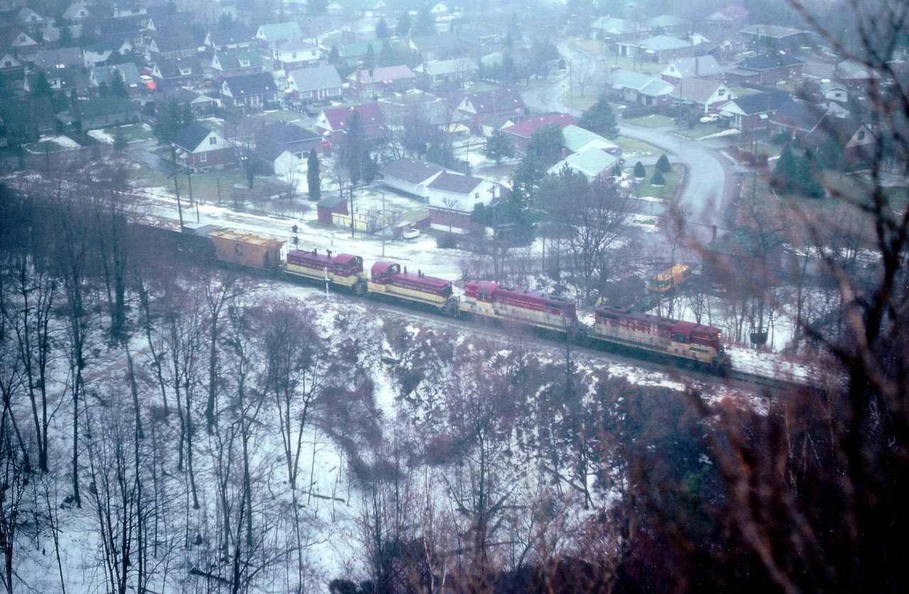 In the endless, perhaps time-wasting, quest for photo locations that no one else could be bothered with, I happened upon the Devil's Punch Bowl in Stoney Creek. Outside chance of a half-decent image here but I had to try it out.  A few days later was in Hamilton and a southbound TH&B was ready to roll from Aberdeen, so off I went. Miserable day. Cold, damp, foggy, and all the rest of it; oddly enough about the same conditions out as I am posting this image 31 years later. Shot a half second too late perhaps, but it was the only time I bothered treking into that spot for a train. TH&B 75, 73, 53 and 57 are seen making the long climb to Vinemount. What do I see? Signals?? A road crossing??? Makes one want to scout this out again come warmer weather and see what remains.