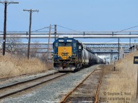 At Sarnia - CSXT Y120 is framed in a canopy of pipelines that join adjacent refineries and chemical plants, whom also depend on the railways service to stay active.<br><br>The crew of Y120 is nearly done for the day, and is seen shoving their 80 car train into Sarnia Yard. Once done, the crew will cut off from their engine and caboose and return to the Clifford St Pere Marquette depot and Erie and Huron built roundhouse light engine.<br><br>I could be wrong, but it appears the flanger sign at right is illuminated or reflective... anyone have info on this?