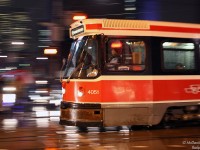 Zipping across the intersection like a red rocket in the night, Toronto Transit Commission CLRV 4051 heads east on Dundas across Bay Street on a wet winter evening, running the 505 Dundas route.