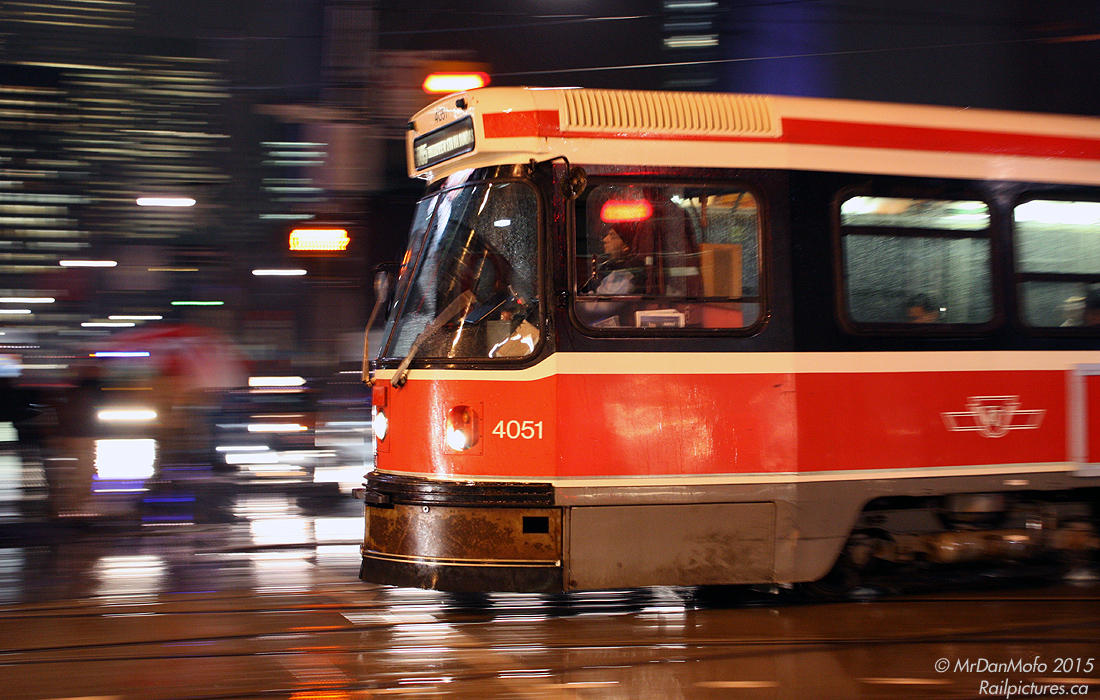 Zipping across the intersection like a red rocket in the night, Toronto Transit Commission CLRV 4051 heads east on Dundas across Bay Street on a wet winter evening, running the 505 Dundas route.