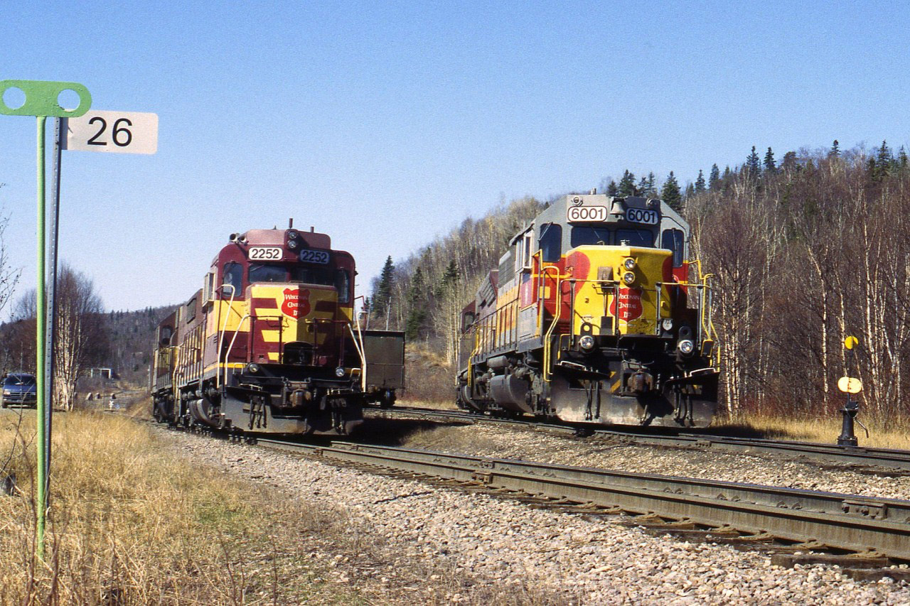 Back when the Wawa sinter plant and the Michipicoten sub still existed, @1998; the scene this day was WC 6590, 6001, 2052 and 2252 brought train of empties to the Harbour, where they were switched out and loads picked up. The power split up; on the right is the empties and the track on the left goes down to the docks. The train will return to Wawa with WC 6001, 6590, 2252 and 2052 in that order. The WC 6001, still in Algoma paint, was formerly the ACR 181. Within the year all this activity would be history. (Mile 26 was the end of the "main".)